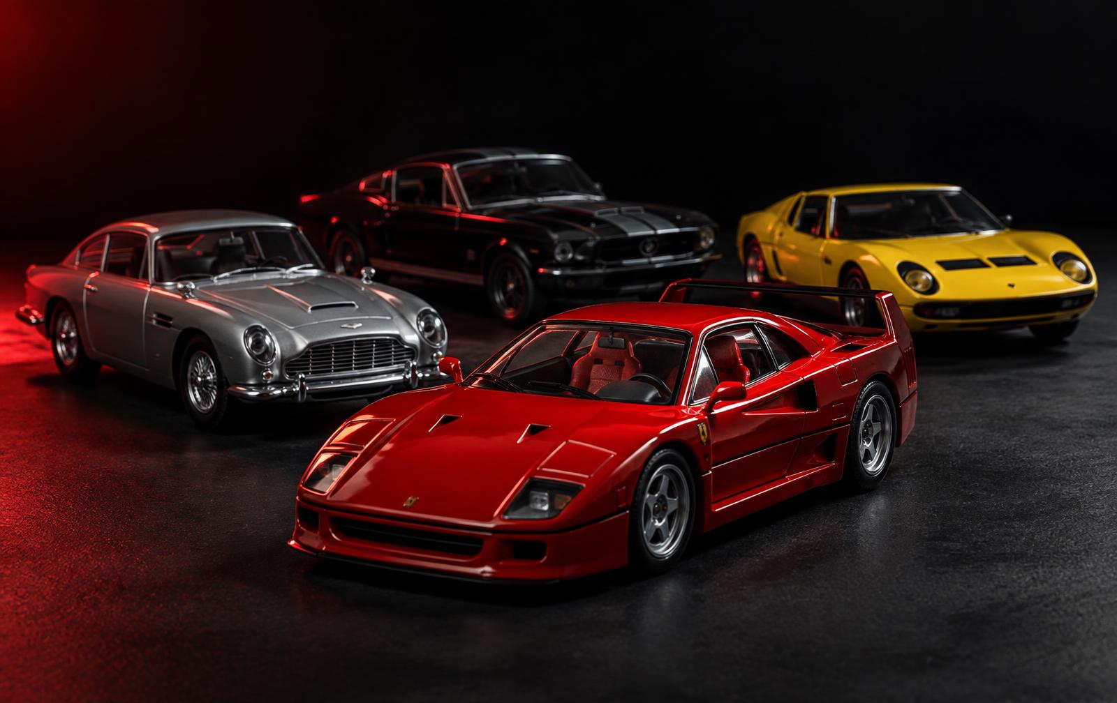 A lineup of collectible diecast model cars under dramatic studio lighting